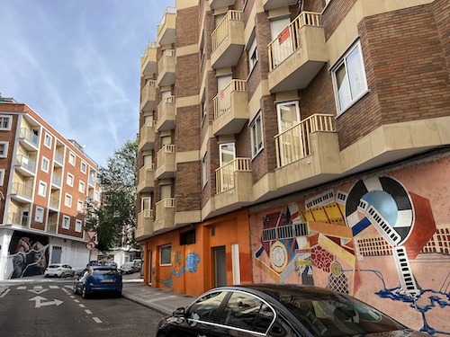 Street in Salamanca with buildings, street art and cars