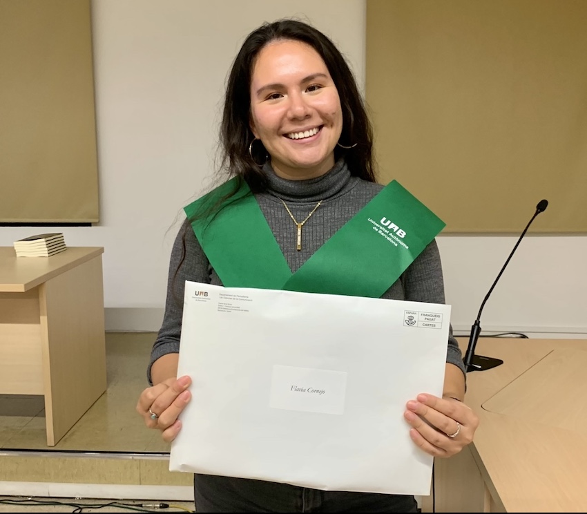 brunette in a gray turtleneck holding a white envelope. How to Live Abroad - Studying Abroad