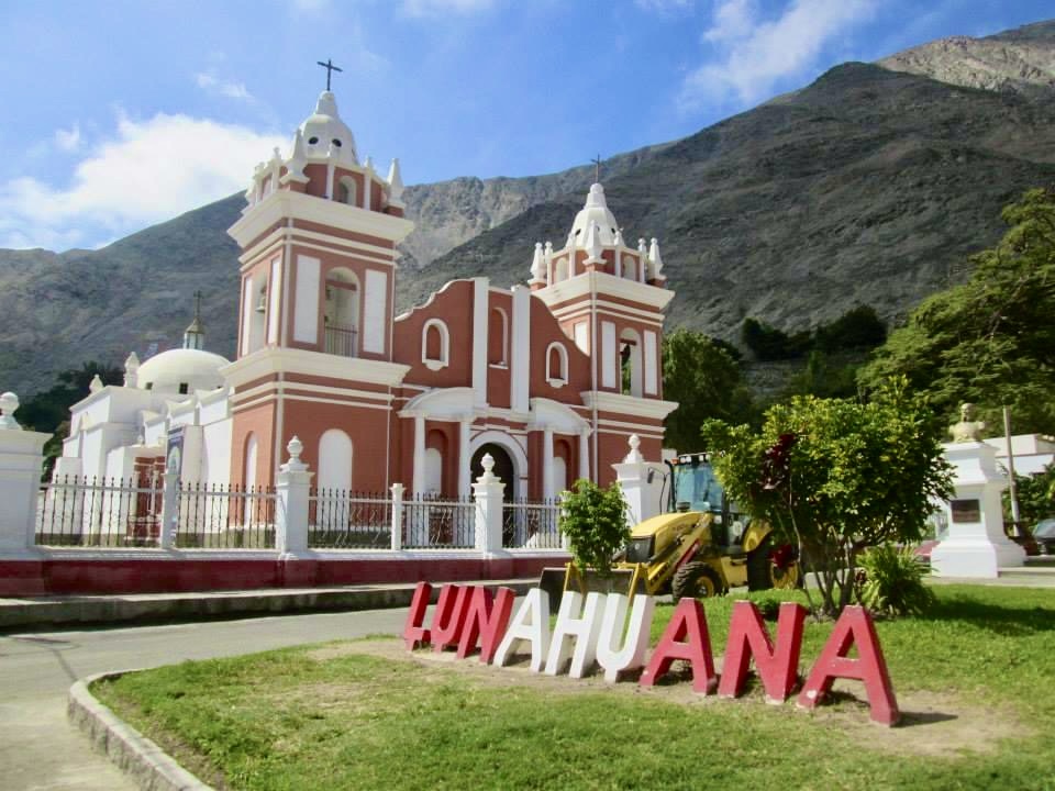 Lunahuana sign in red and white in front of a church in the main square