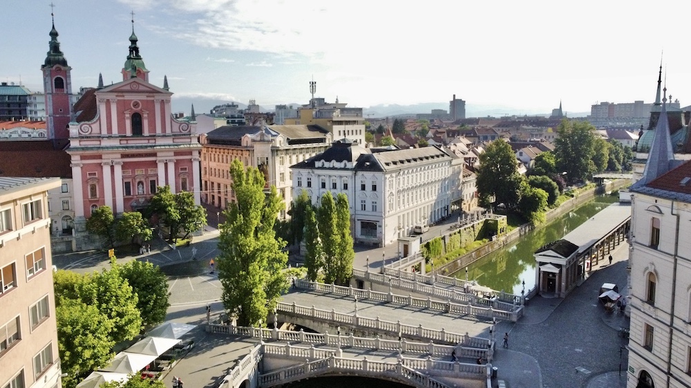 Ljubljana drone view of pink church, three bridges and Ljubljanica river