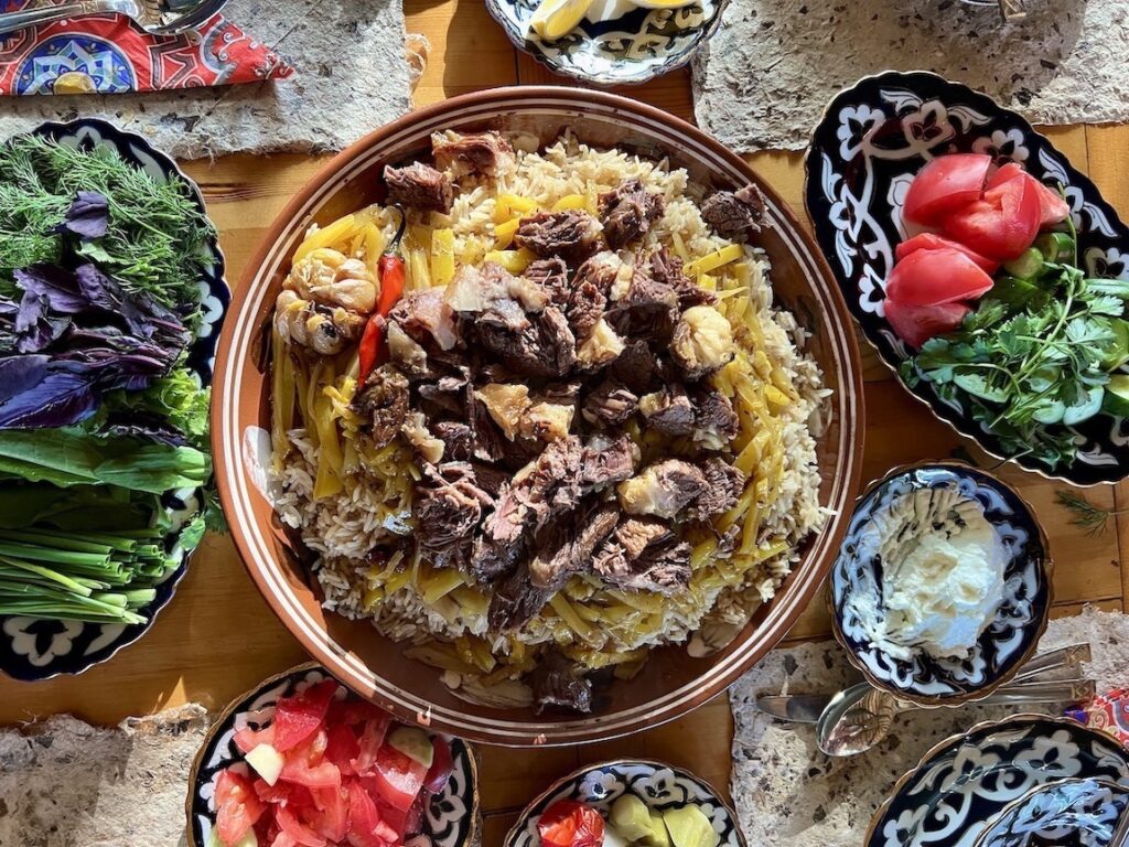 Plov and salads on table