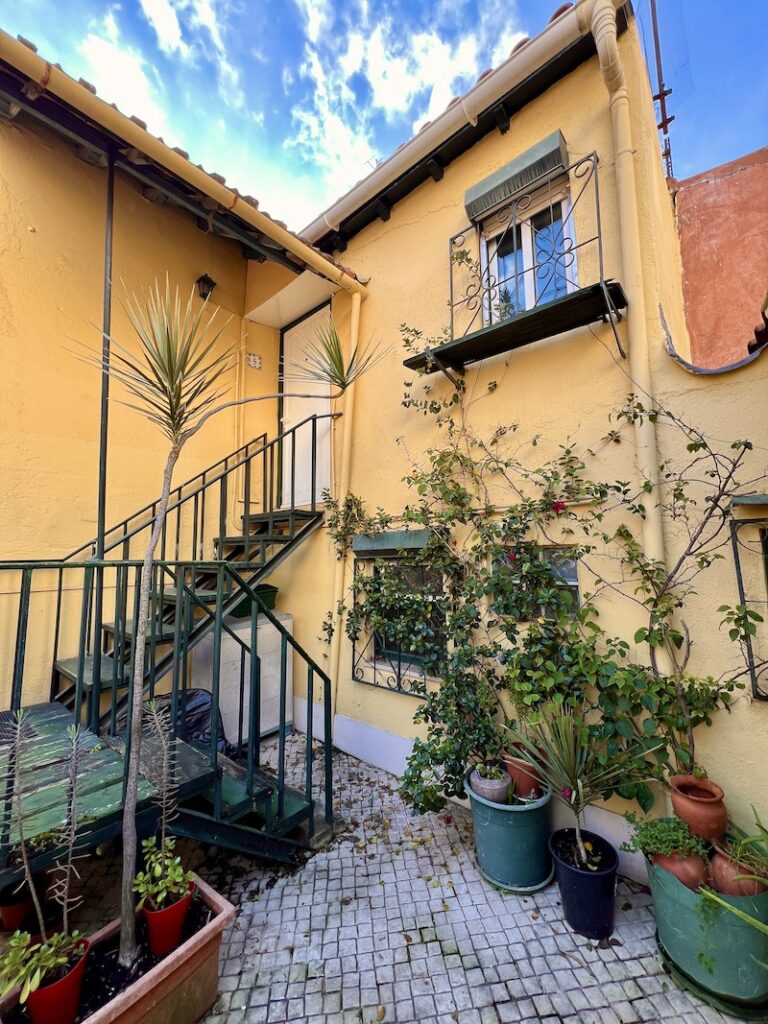 yellow lisbon apartment with green stairs and plants and a blue sky, 2024 year in review