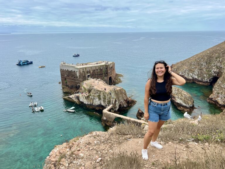brunette standing on a cliff overlooking the Fortress off the island of Berlengas