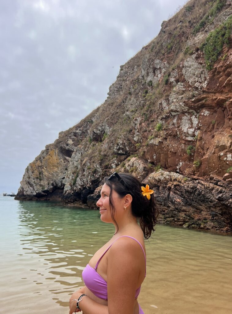 brunette wearing a purple bikini top and a yellow flower clip in hair at Berlengas beach